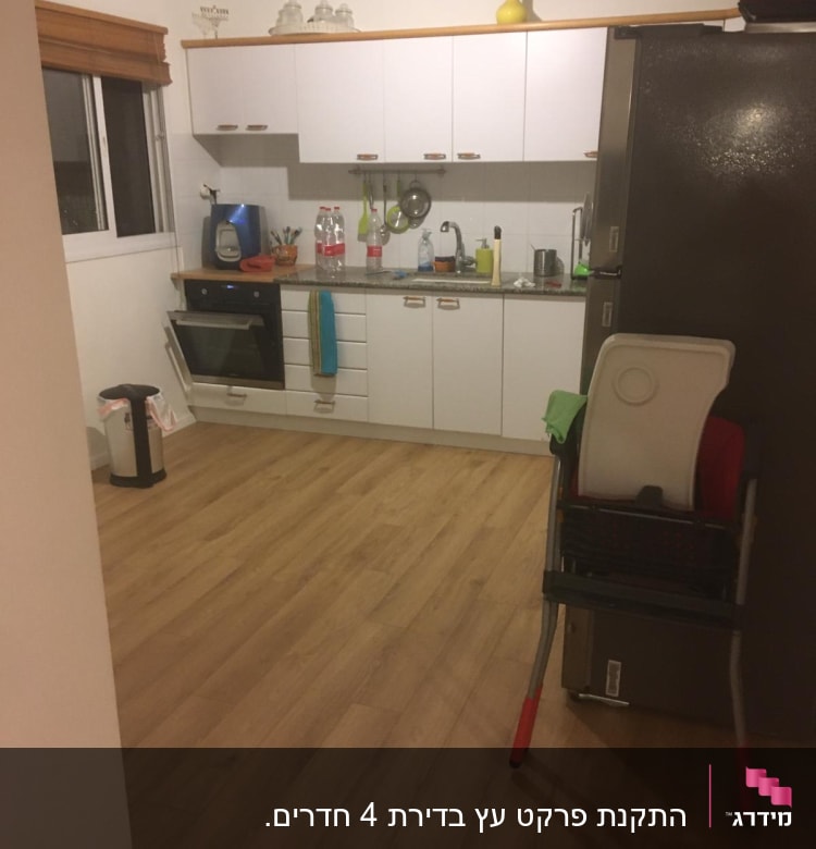 רצפת פרקט עץ במטבח מודרני עם ארונות לבנים